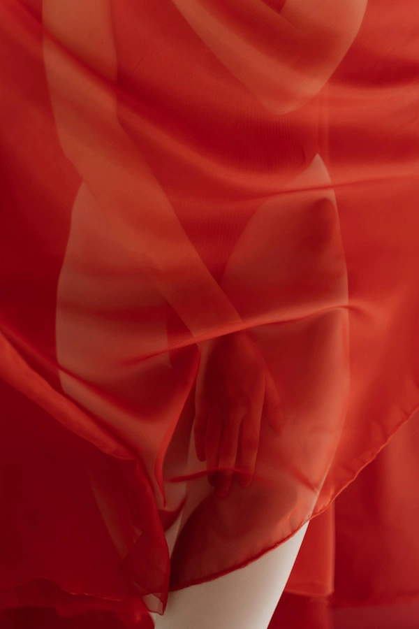 A red toy held by 2 hands